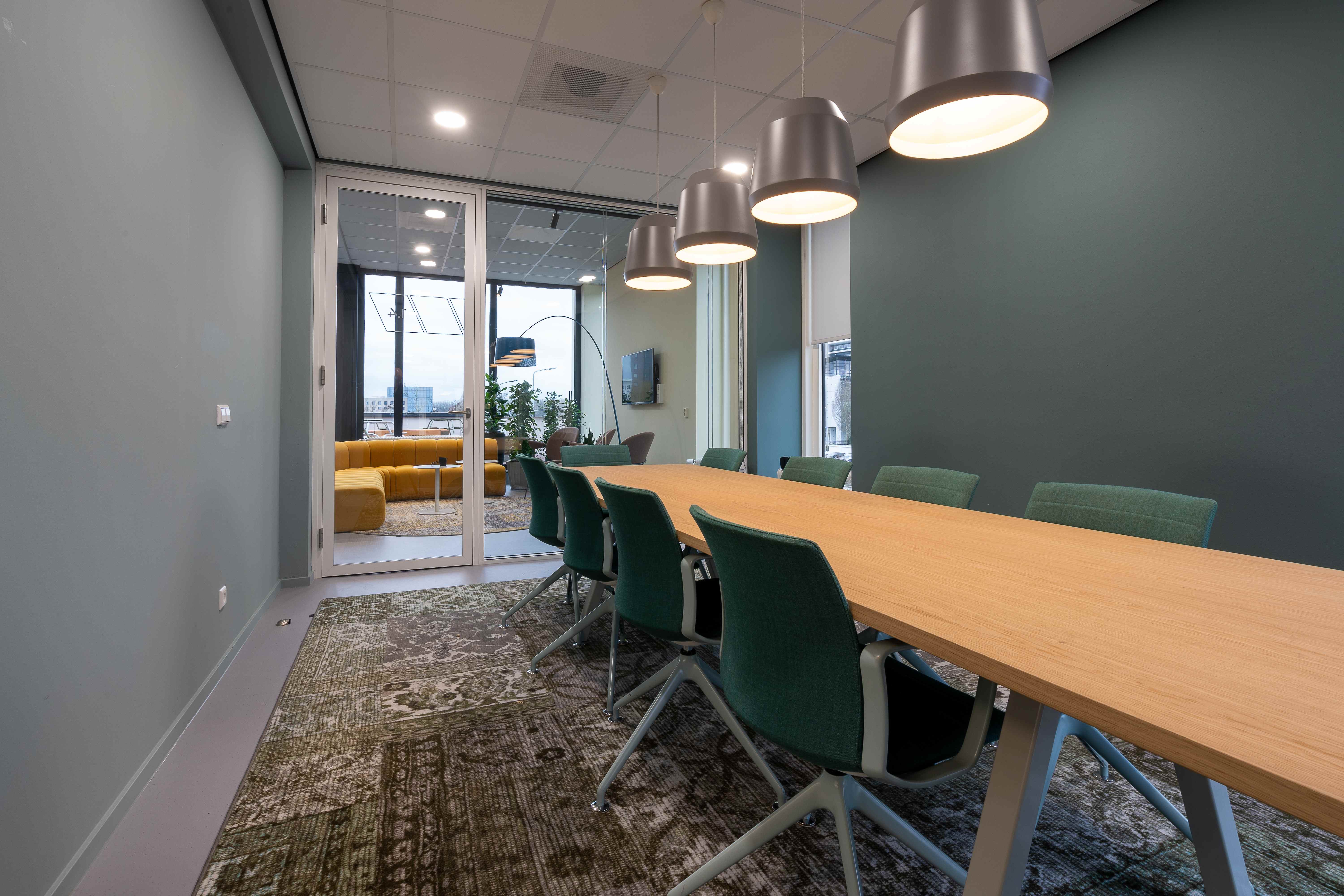 Modern office lounge with green walls and pendant lighting